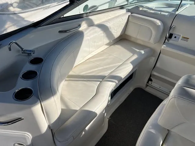 Slide: The Image of 2009 Bayliner 245 Cruiser interior with white leather seating and cup holders. - 6