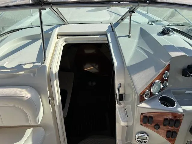 Slide: The Image of 2009 Bayliner 245 Cruiser cockpit with open cabin door and control panel. - 9