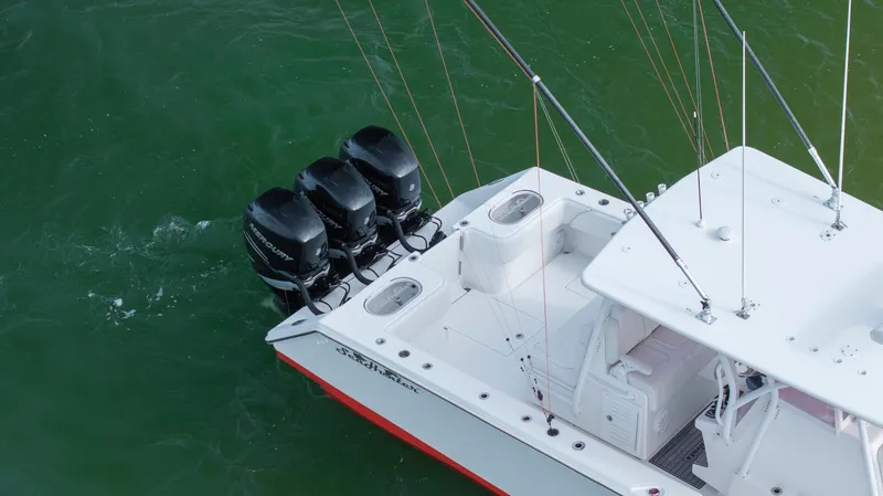 Slide: The Image of 2024 SeaHunter 35 Tournament boat with triple outboard engines on green water. - 12