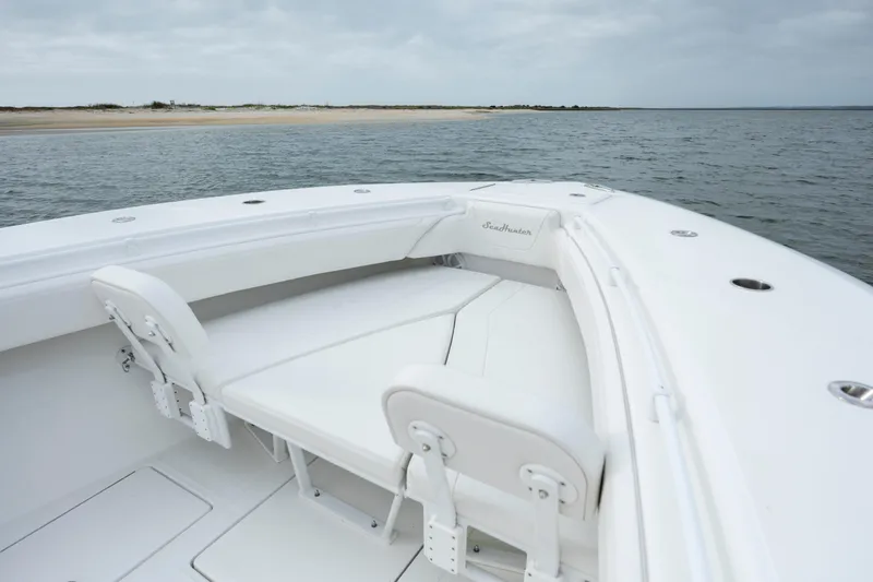 Slide: The Image of 2024 SeaHunter 35 Tournament boat interior with seating, near a sandy shoreline. - 33