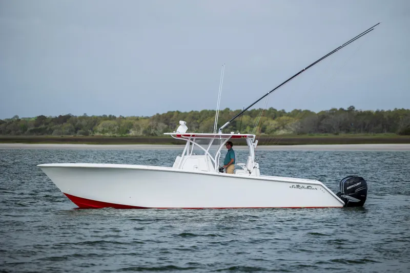 Slide: The Image of 2024 SeaHunter 35 Tournament boat on water, side view, with trees in the background. - 45