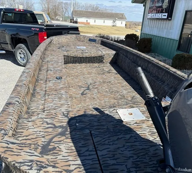 Slide: The Image of 2025 Xpress H16DB boat with camouflage pattern parked near a building. - 4