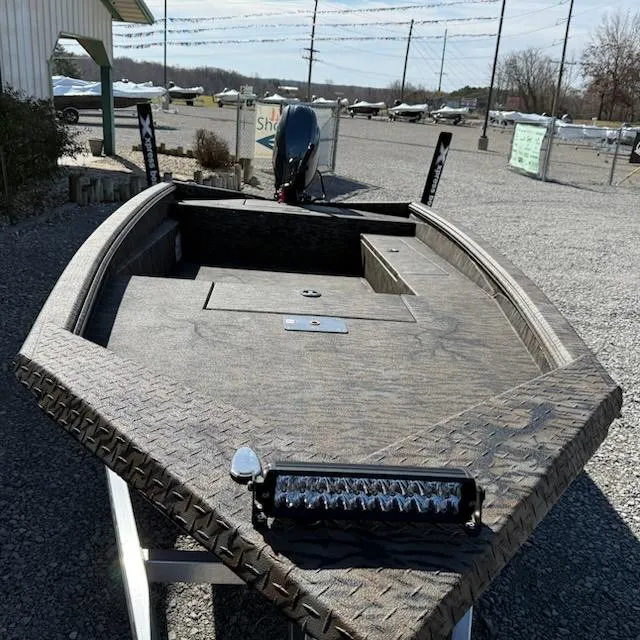 Slide: The Image of 2025 Xpress H16DB boat with textured deck, parked outdoors. - 5