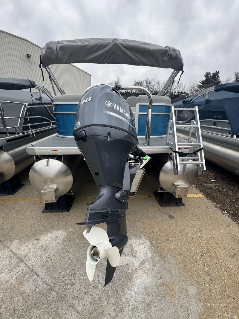 Slide: The Image of 2025 Godfrey EX2286SBX pontoon boat with Yamaha outboard motor, docked outdoors. - 11