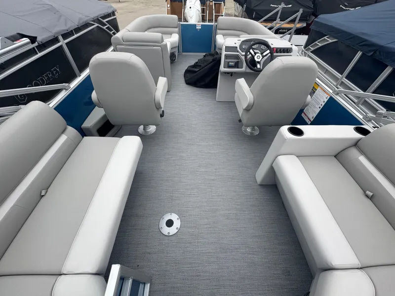 Slide: The Image of 2025 Godfrey EX2286SBX pontoon boat interior with gray seating and steering console. - 14