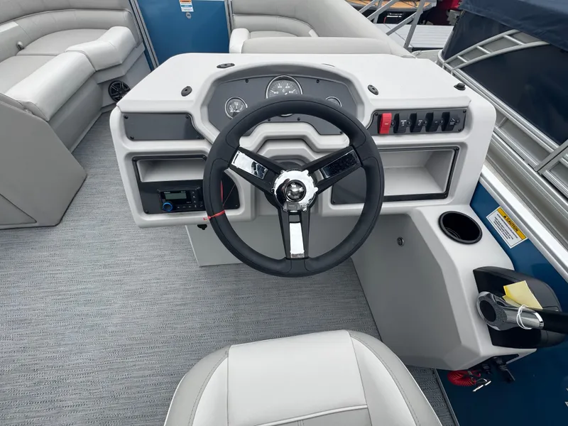 Slide: The Image of 2025 Godfrey EX2286SBX boat dashboard with steering wheel and control panel. - 16