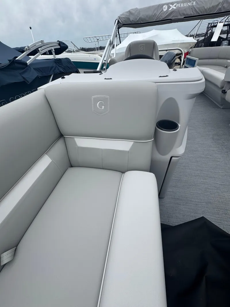 Slide: The Image of 2025 Godfrey EX2286SBX boat interior with gray seating and cup holder. - 4