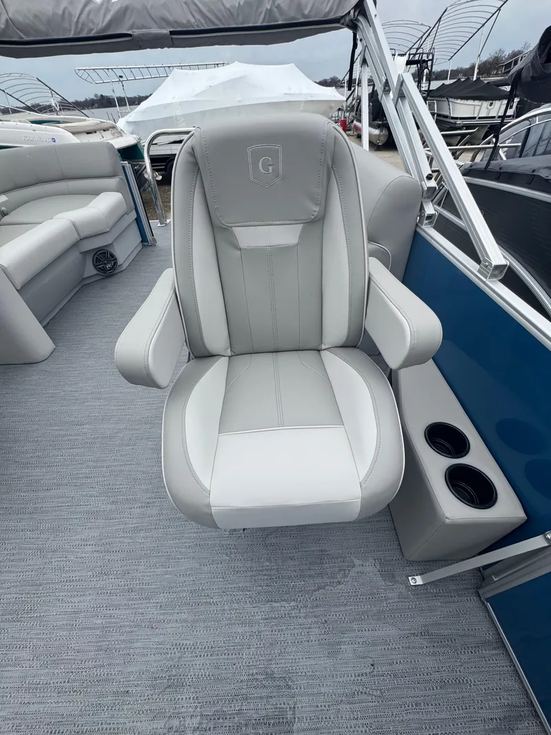 Slide: The Image of Captain's chair on 2025 Godfrey EX2286SBX pontoon boat, featuring gray upholstery and armrests. - 8