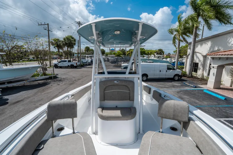 Slide: The Image of 2025 Sea Hunt Ultra 234 boat with seating, parked outdoors under a blue sky. - 23