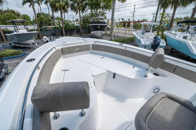 Slide: The Image of 2025 Sea Hunt Ultra 234 boat interior with seating and storage, surrounded by other boats. - 25