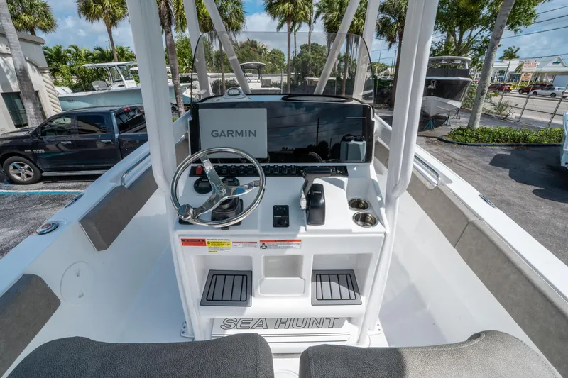 Slide: The Image of 2025 Sea Hunt Ultra 234 boat dashboard with Garmin navigation system, steering wheel, and controls. - 15