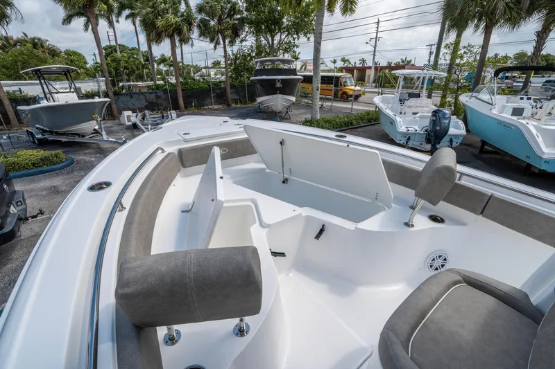 Slide: The Image of 2025 Sea Hunt Ultra 234 boat interior with seating and storage, displayed outdoors. - 24