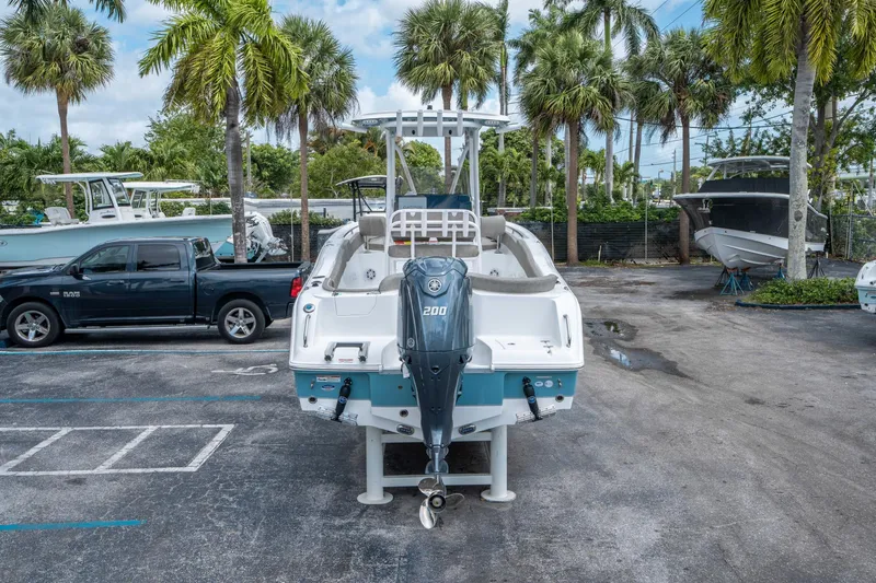 Slide: The Image of 2025 Sea Hunt Ultra 234 boat with Yamaha 200 engine, parked near palm trees. - 3