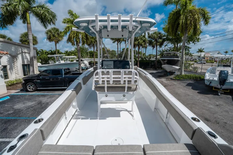 Slide: The Image of 2025 Sea Hunt Ultra 234 boat in a sunny marina with palm trees. - 9