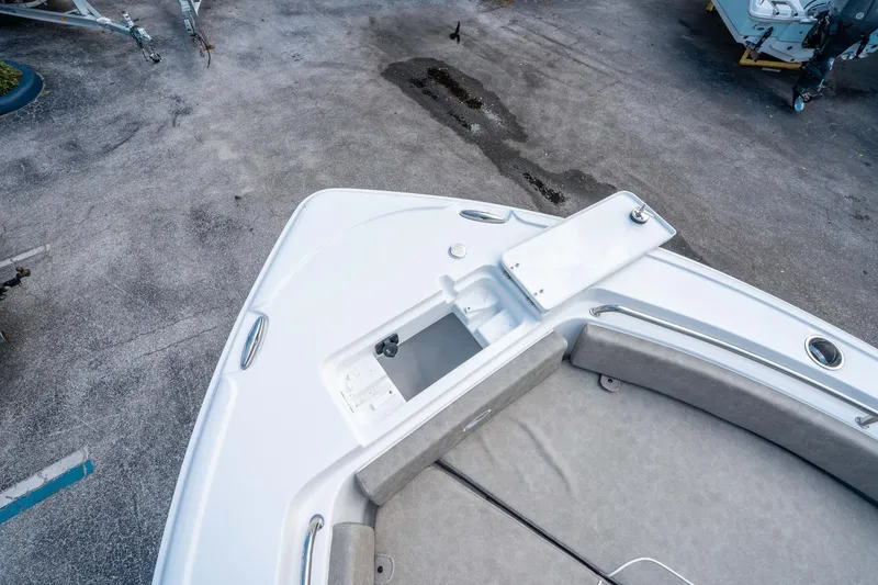 Slide: The Image of 2025 Sea Hunt Ultra 234 boat deck with open storage compartment. - 27