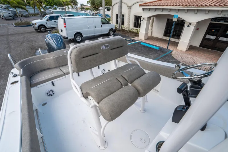 Slide: The Image of 2025 Sea Hunt Ultra 234 boat interior with cushioned seating and steering console. - 28