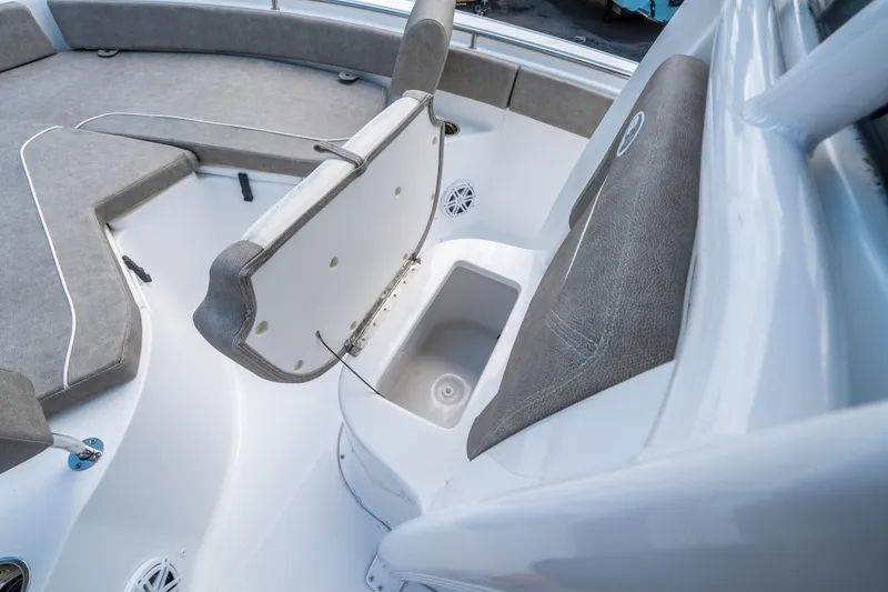 Slide: The Image of 2025 Sea Hunt Ultra 234 boat interior with open storage compartment and cushioned seating. - 26