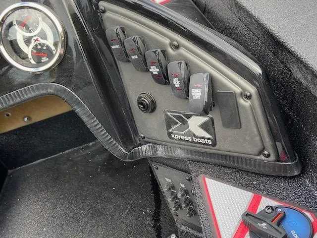 Slide: The Image of 2024 Xpress X19 Pro boat dashboard with control switches and gauges. - 7