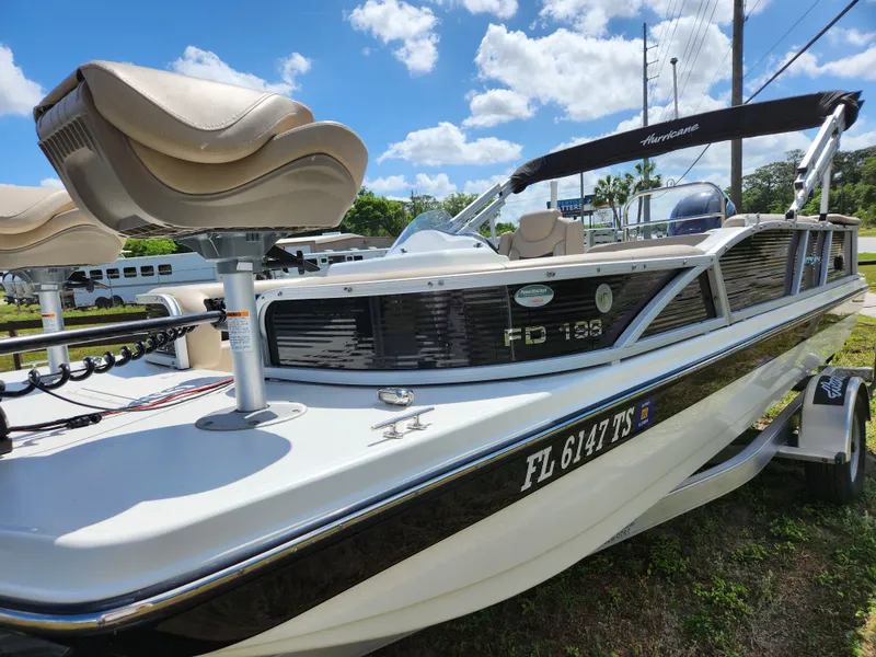 Slide: The Image of 2023 Hurricane Fundeck 198 Fish Package boat with seating, parked outdoors under a blue sky. - 5