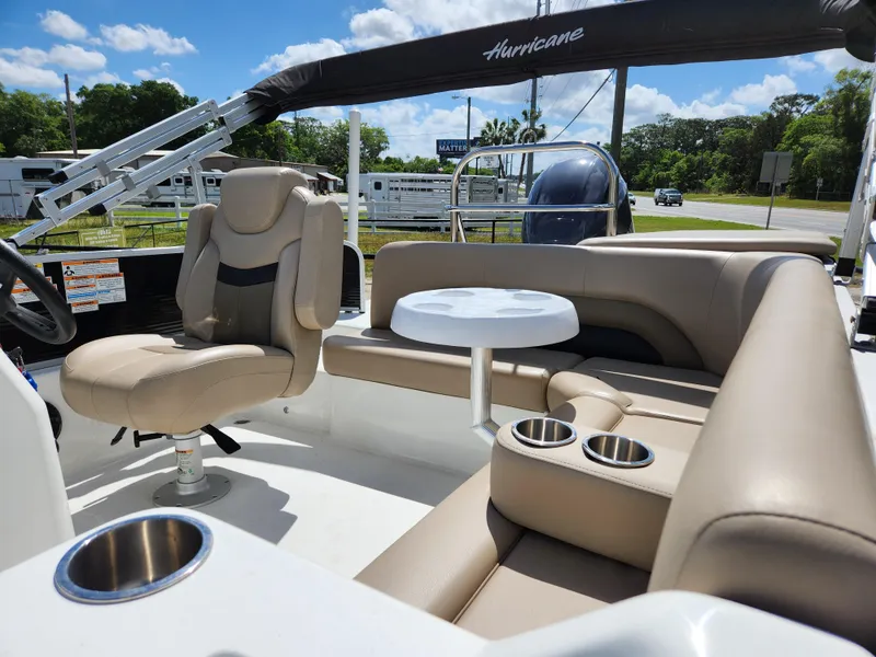 Slide: The Image of 2023 Hurricane Fundeck 198 Fish Package with beige seating and cup holders under blue sky. - 8