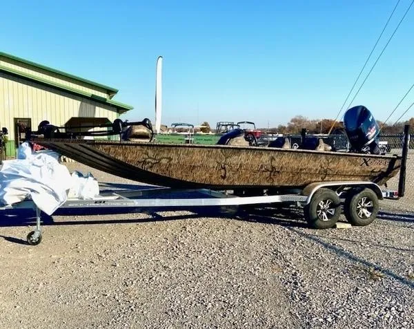 The Image of 2024 Xpress XP200 boat on trailer, parked outdoors near a building. - 1