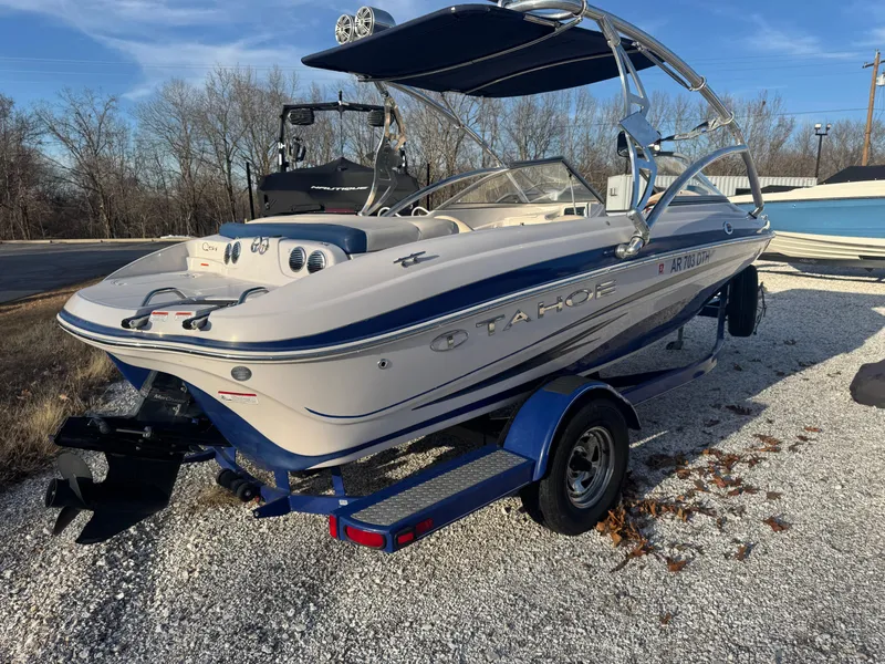 Slide: The Image of 2011 Tracker Tahoe Q5i boat on trailer, parked outdoors on gravel. - 8
