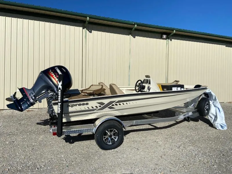 Slide: The Image of 2024 Xpress H18C boat with trailer, parked outdoors near a beige building. - 1