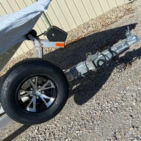 Slide: The Image of Trailer hitch and wheel of 2024 Xpress H18C boat on gravel surface. - 10