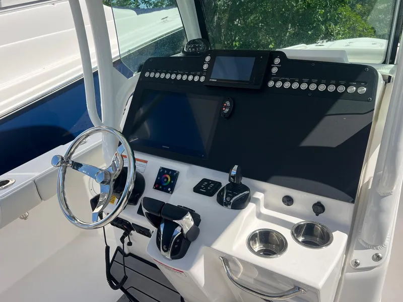 Slide: The Image of 2022 Everglades 273 CC boat dashboard with steering wheel and control panel. - 10