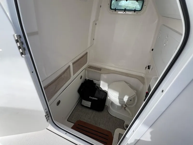 Slide: The Image of 2022 Everglades 273 CC boat interior with compact marine toilet and storage. - 15