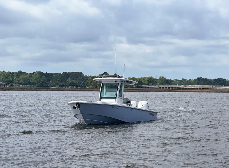Slide: The Image of 2022 Everglades 273 Center Console boat cruising on a calm lake under cloudy skies. - 3