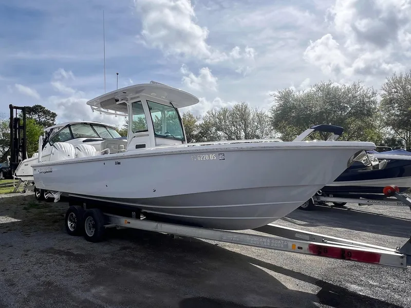 Slide: The Image of 2022 Everglades 273 Center Console boat on trailer under cloudy sky. - 31