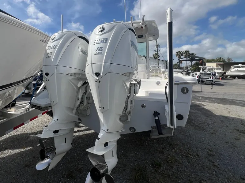 Slide: The Image of 2022 Everglades 273 Center Console boat with twin Yamaha 300 engines, docked outdoors. - 32