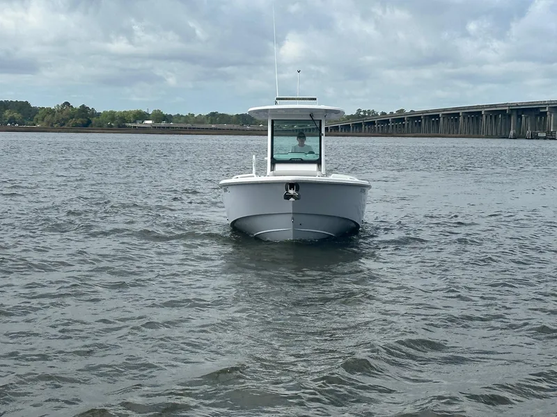 Slide: The Image of 2022 Everglades 273 Center Console boat on water near a bridge under cloudy skies. - 8