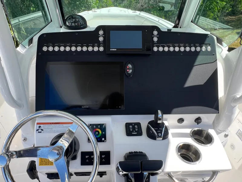 Slide: The Image of 2022 Everglades 273 CC boat dashboard with steering wheel and electronic controls. - 9
