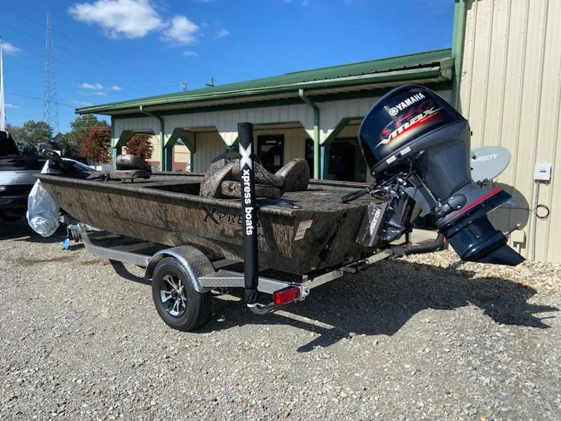 Slide: The Image of 2024 Xpress XP185 Catfish boat with Yamaha motor, parked outside a building. - 1