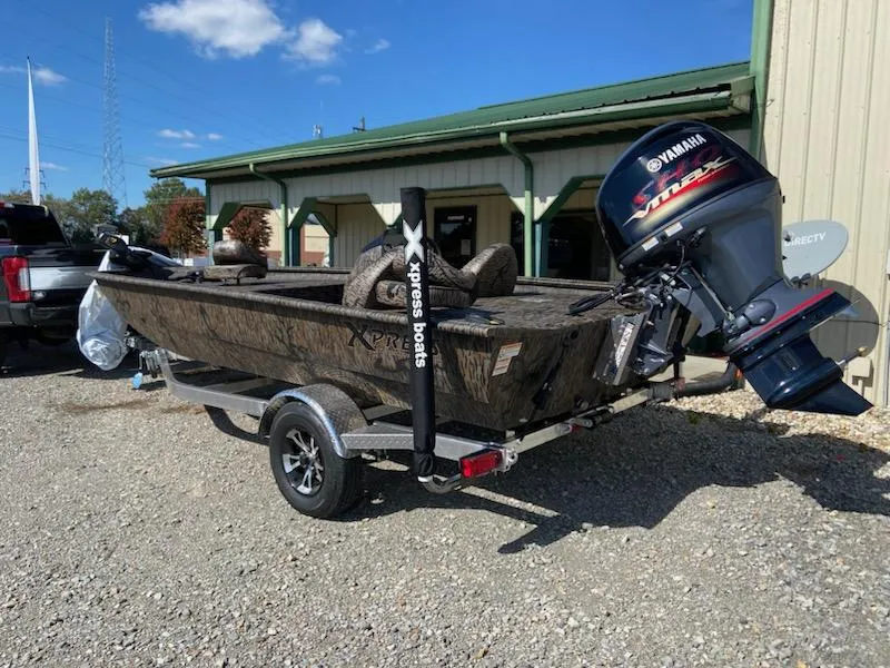 Slide: The Image of 2024 Xpress XP185 Catfish boat with Yamaha engine on trailer, parked outdoors. - 2