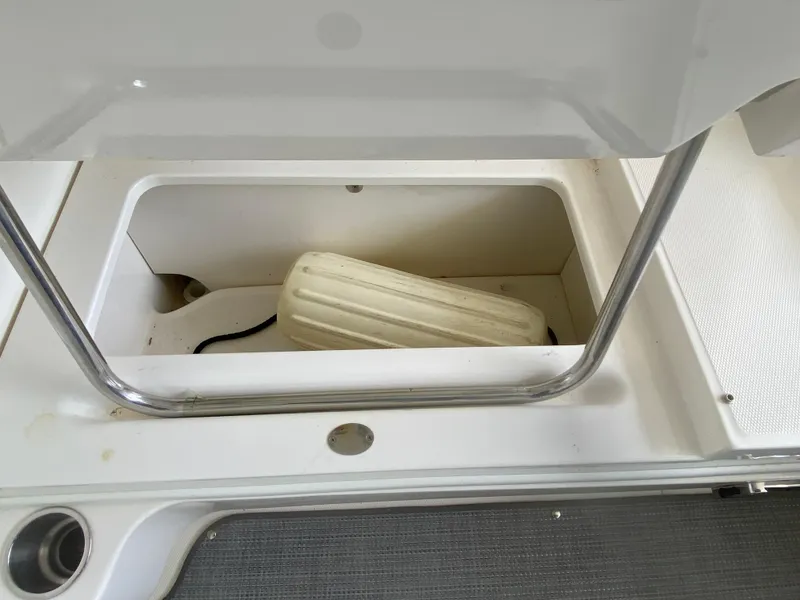 Slide: The Image of Storage compartment on a 2010 Sea Ray 300 SLX boat with a fender inside. - 12