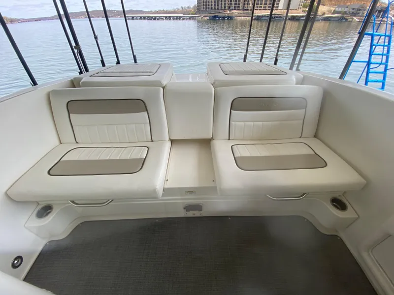 Slide: The Image of 2010 Sea Ray 300 SLX boat interior with cushioned seating by the water. - 14