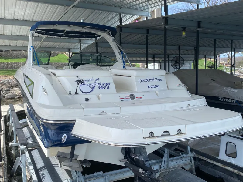 Slide: The Image of 2010 Sea Ray 300 SLX boat docked in covered marina, featuring sleek design and spacious deck. - 3