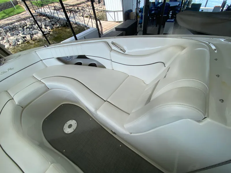 Slide: The Image of Luxurious seating on a 2010 Sea Ray 300 SLX boat, docked near a rocky shoreline. - 36
