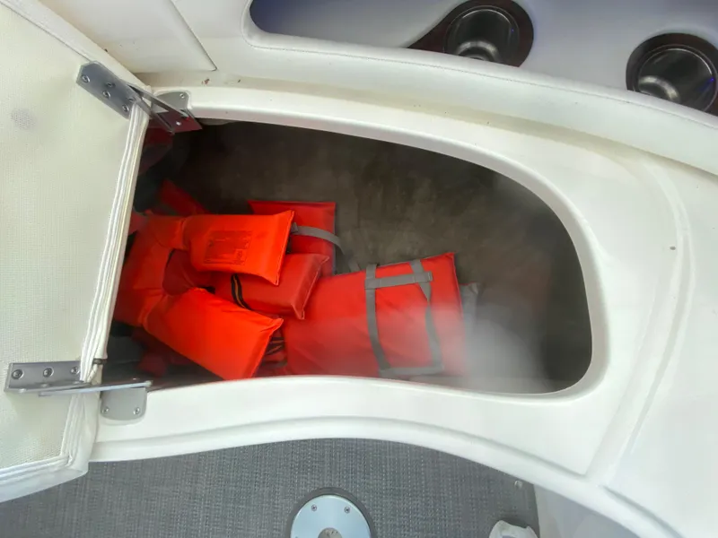 Slide: The Image of Storage compartment with orange life jackets on a 2010 Sea Ray 300 SLX boat. - 38