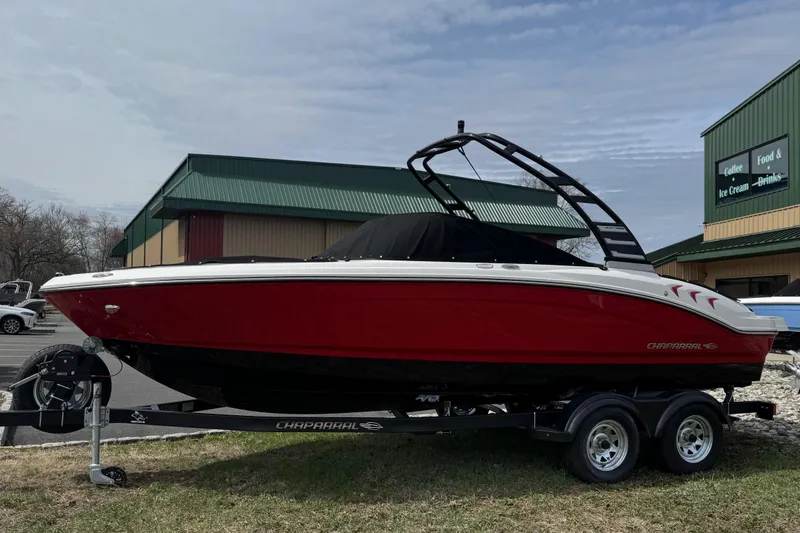 The Image of 2025 Chaparral 21 SSi boat on trailer, red and white design, parked outdoors. - 0