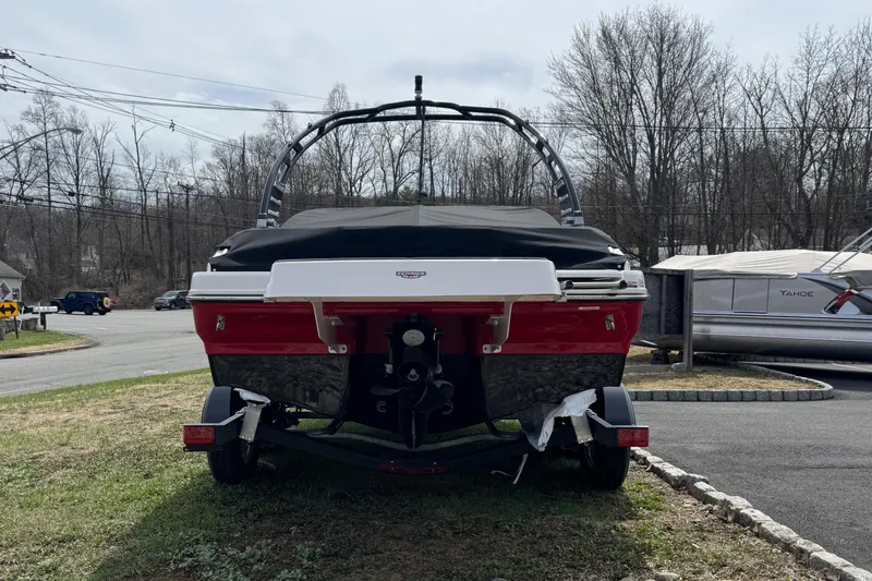 Slide: The Image of 2025 Chaparral 21 SSi boat, rear view, parked on grass with cover. - 3