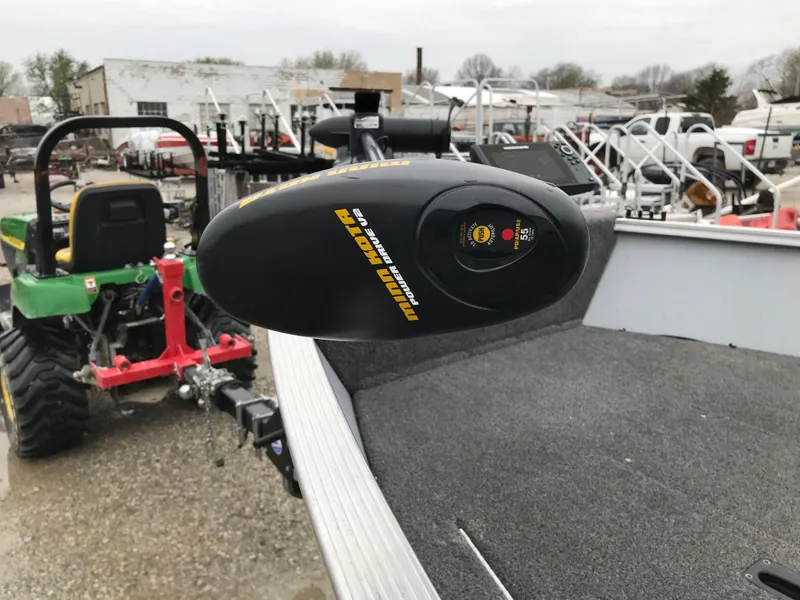 Slide: The Image of 2016 Lund 1600 Rebel SS boat with Minn Kota trolling motor in a yard. - 10