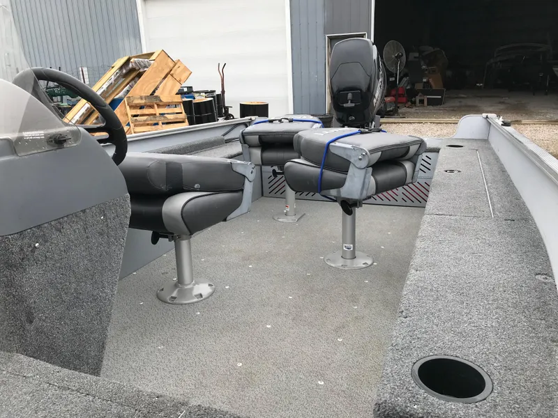 Slide: The Image of 2016 Lund 1600 Rebel SS boat interior with gray seating and steering wheel. - 11