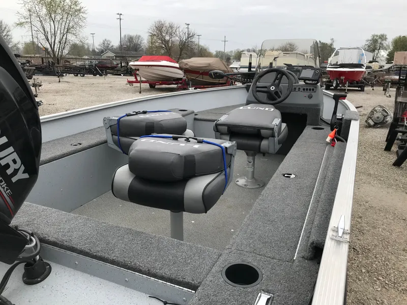 Slide: The Image of 2016 Lund 1600 Rebel SS fishing boat with dual seats and steering console in a boatyard. - 13