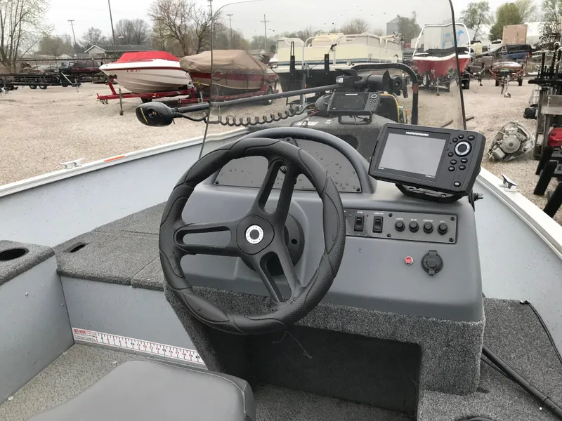 Slide: The Image of 2016 Lund 1600 Rebel SS boat dashboard with steering wheel and navigation system. - 15