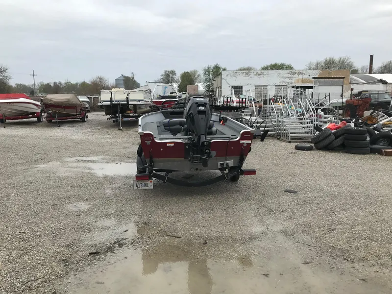 Slide: The Image of 2016 Lund 1600 Rebel SS boat in a gravel lot with trailers and equipment. - 3
