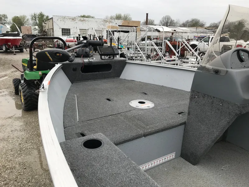 Slide: The Image of 2016 Lund 1600 Rebel SS boat interior with gray carpet and steering console. - 9